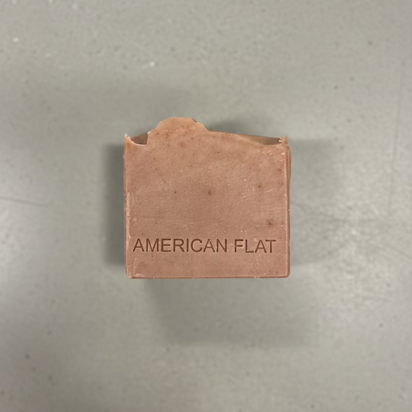 Bar of Wild Patchouli artisan soap with 'American Flat' branding on a wooden surface