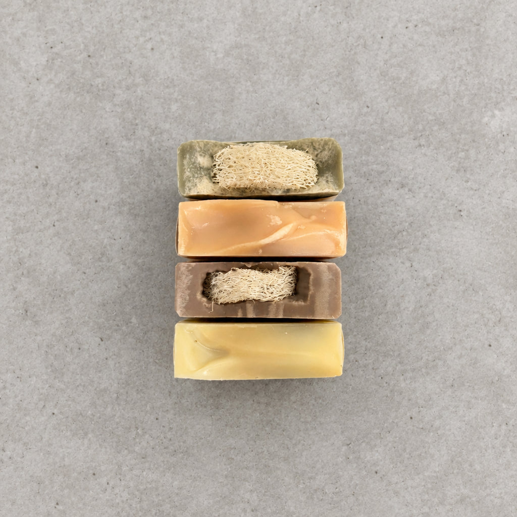 4 bars of soap on a concrete countertop.