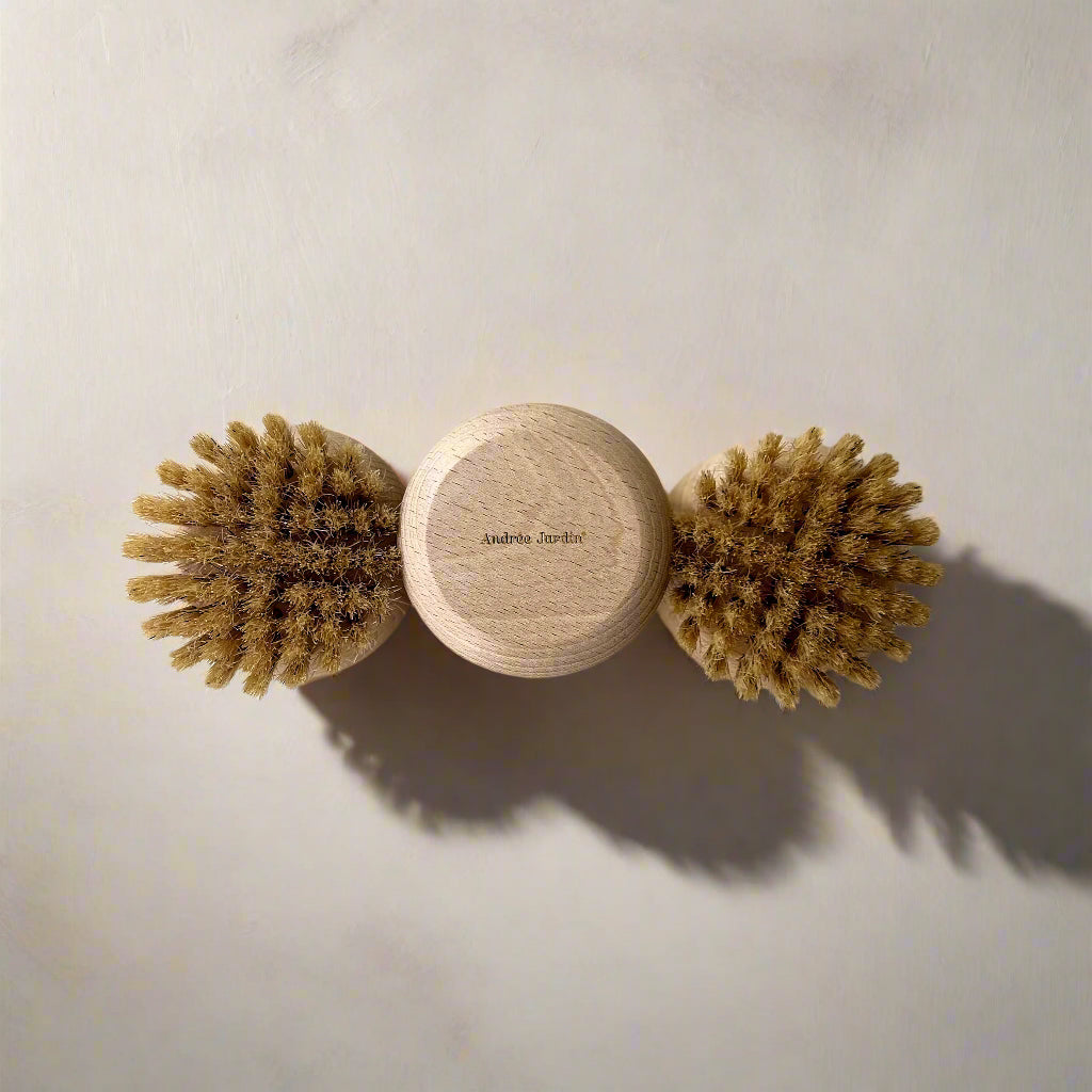 Three round natural bristle brushes with wooden handles on a white background