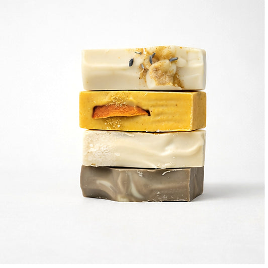 Stack of three handmade soap bars with natural textures and colors on a white background