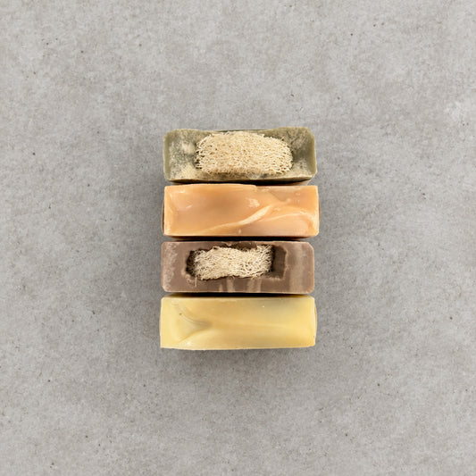 4 bars of soap on a concrete countertop. 
